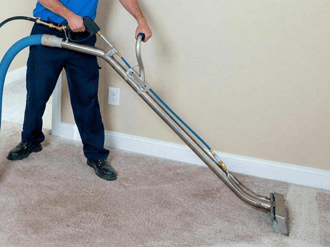 Professional operating a liquid removal machine on a carpeted floor in Boca Raton, FL